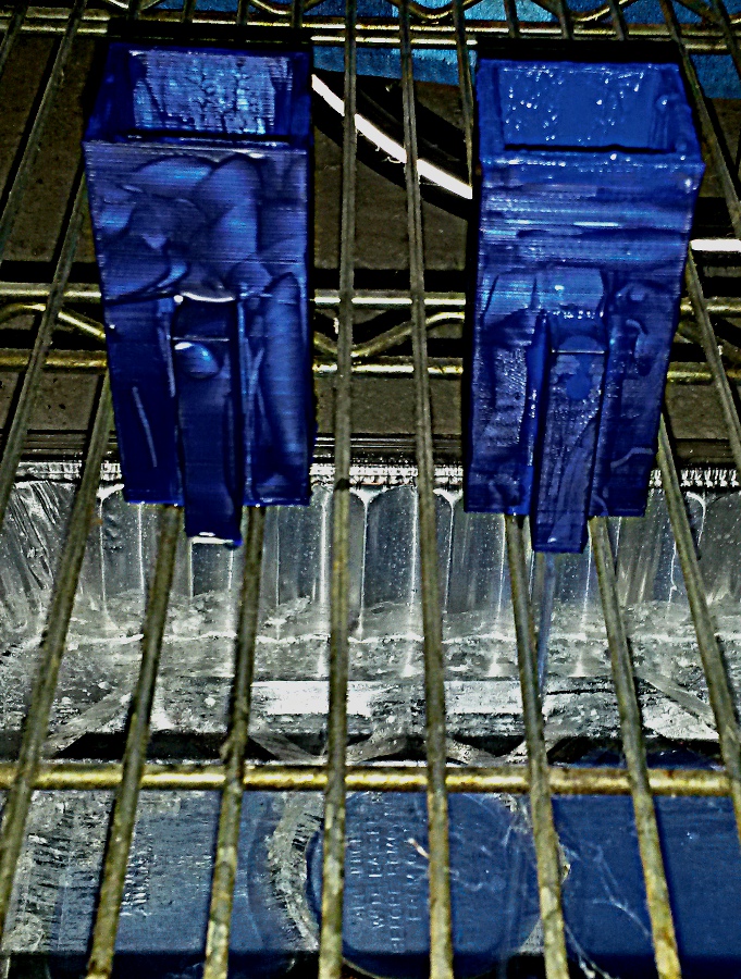 3d-printed hydraulic AND gates, painted with acrylic paint in an ultramarine colour; the one on the right is discharging through the siphon